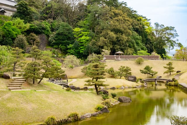 Estanque, pinos y césped del jardín Kenrokuen en Kanazawa, Japón