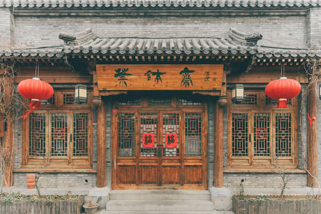 Front view of a traditional Chinese building decorated with red lanterns and wooden doors.