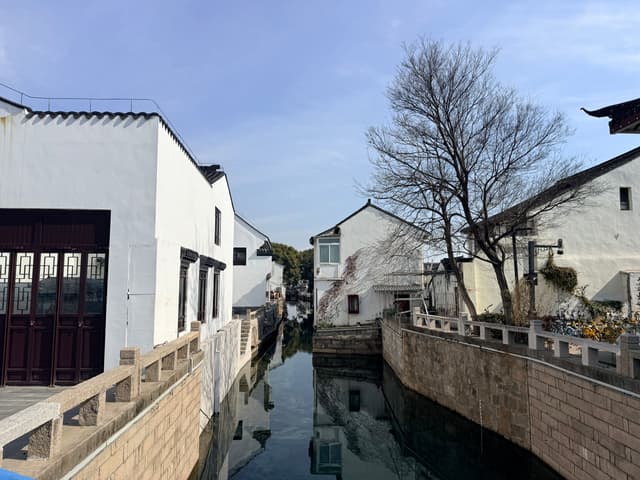 Cases emblanquinades al llarg d'un canal tranquil a Suzhou